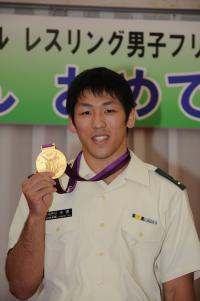 米満達弘選手が、祝賀会で、獲得した金メダルを会場の皆さんに披露している場面の写真です。